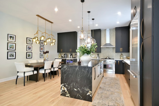 262 N Addison Ave, Elmhurst, IL 60126 - kitchen with wall chimney exhaust hood, a kitchen island, backsplash, dark cabinetry, and recessed lighting