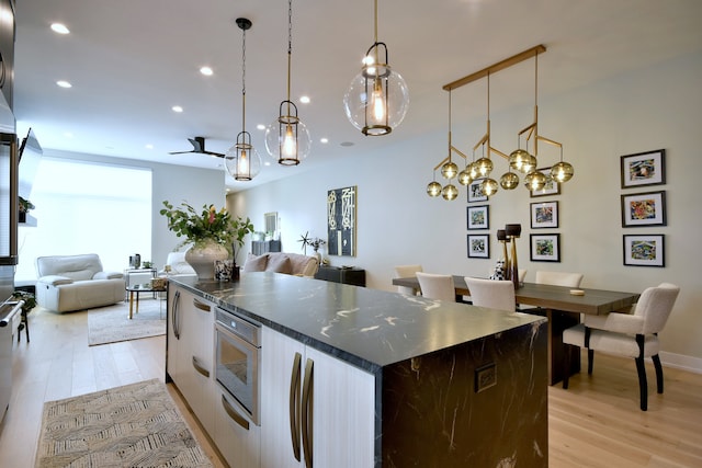 262 N Addison Ave, Elmhurst, IL 60126 - kitchen with recessed lighting, a center island, light wood-style floors, dark countertops, and open floor plan
