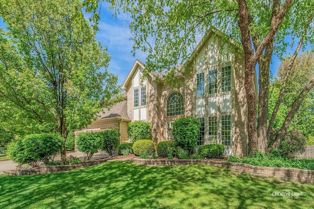 view of front facade with brick siding and a front yard