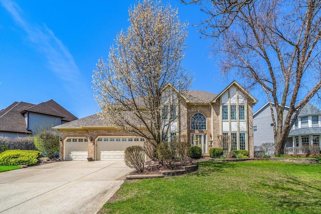 view of front of property with an attached garage, driveway, a front lawn, and brick siding