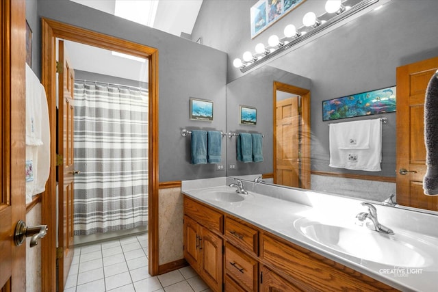 bathroom with tile patterned floors, double vanity, a shower with shower curtain, and a wainscoted wall