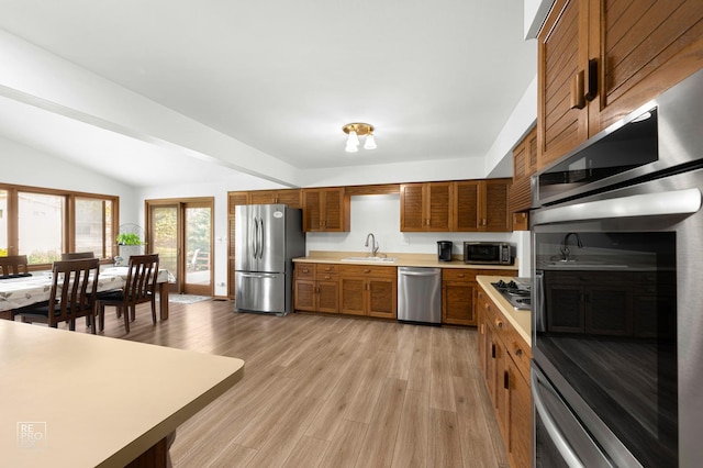 632 Columbine Ave, Lisle, IL 60532 - kitchen featuring stainless steel appliances, light countertops, brown cabinetry, light wood-style floors, and lofted ceiling