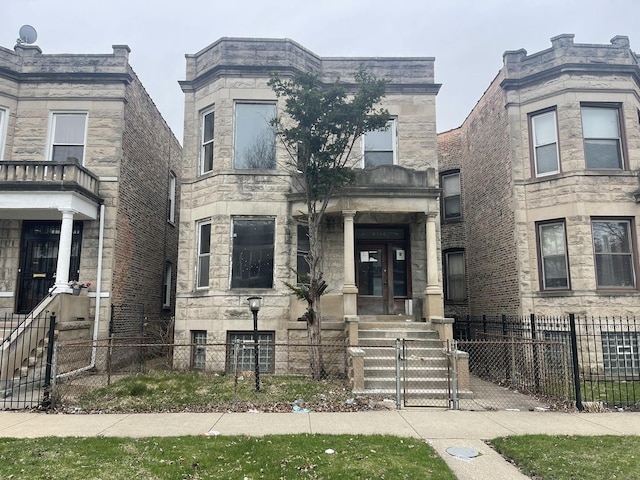 view of front of house with french doors, a fenced front yard, stone siding, and a gate