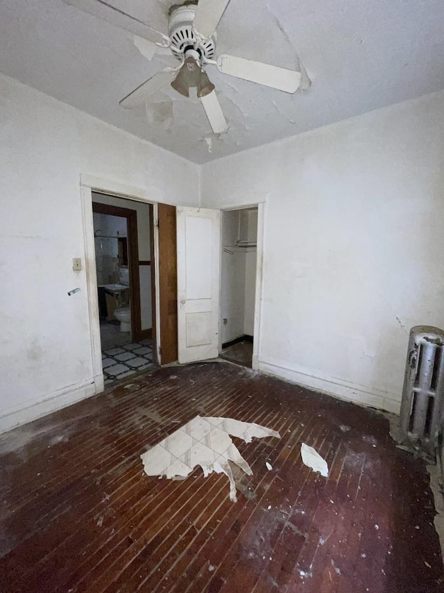 unfurnished bedroom featuring hardwood / wood-style floors, a closet, baseboards, and a ceiling fan