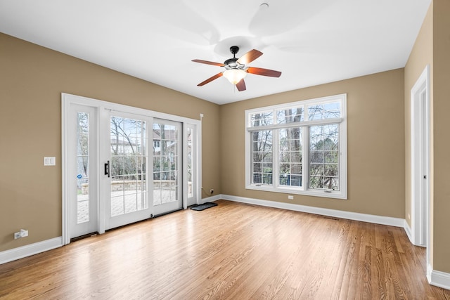 spare room with wood finished floors, baseboards, and a ceiling fan
