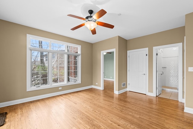 unfurnished bedroom with ensuite bath, light wood-style flooring, baseboards, and visible vents