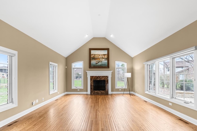 unfurnished living room with light wood-style flooring, visible vents, and plenty of natural light