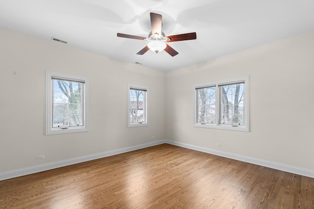 unfurnished room with visible vents, baseboards, a ceiling fan, and wood finished floors