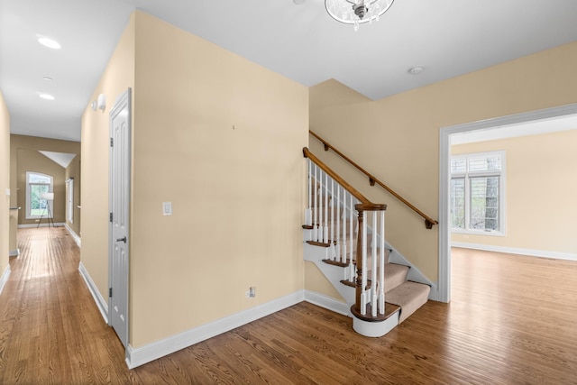 staircase featuring baseboards and wood finished floors
