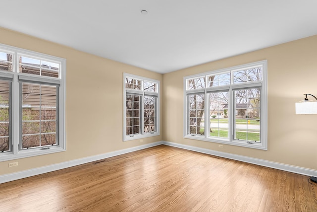 unfurnished room with light wood-style flooring and baseboards