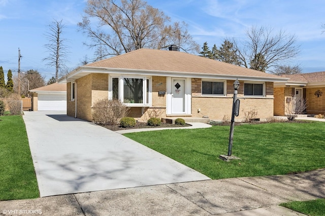 single story home featuring an outbuilding, a garage, a front yard, and brick siding