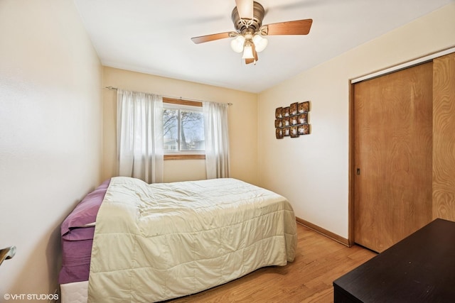 bedroom with a closet, baseboards, a ceiling fan, and light wood-style floors