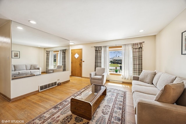 living room featuring recessed lighting, visible vents, light wood-type flooring, and baseboards