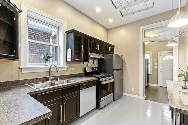 kitchen featuring pendant lighting, recessed lighting, appliances with stainless steel finishes, under cabinet range hood, and a sink