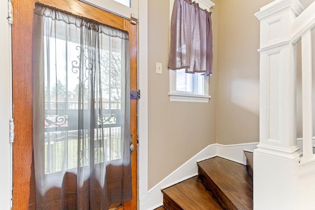 foyer entrance with baseboards and stairway