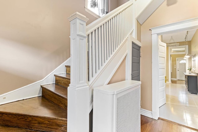 staircase featuring wood-type flooring and baseboards
