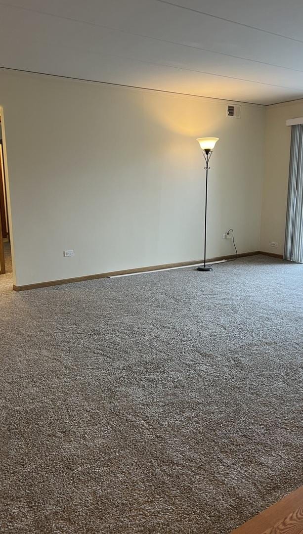 carpeted empty room with baseboards and visible vents