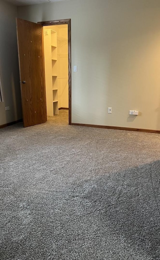 empty room with baseboards and carpet