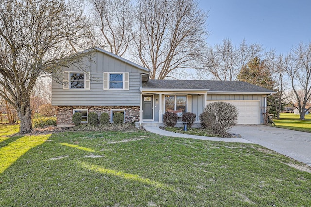 split level home featuring an attached garage, board and batten siding, concrete driveway, and a front yard