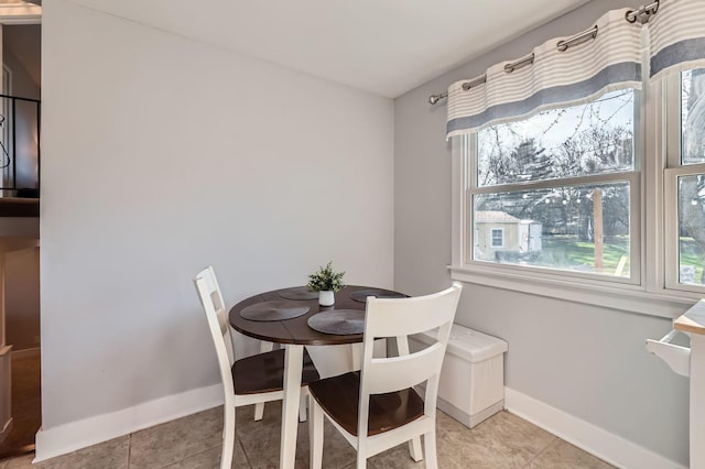 dining space with light tile patterned floors and baseboards
