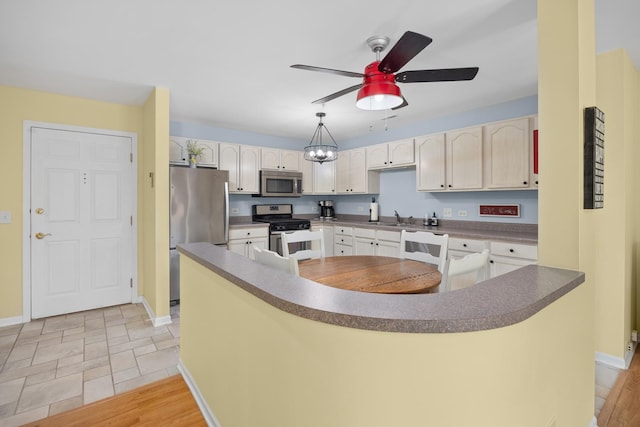 17 E Hattendorf Ave Unit 205, Roselle, IL 60172 - kitchen with appliances with stainless steel finishes, dark countertops, ceiling fan, light stone finish flooring, and a center island