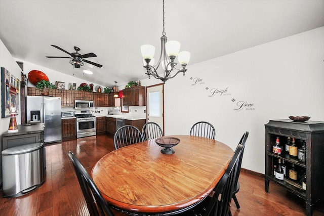 dining area with baseboards, dark wood-style floors, ceiling fan with notable chandelier, and vaulted ceiling