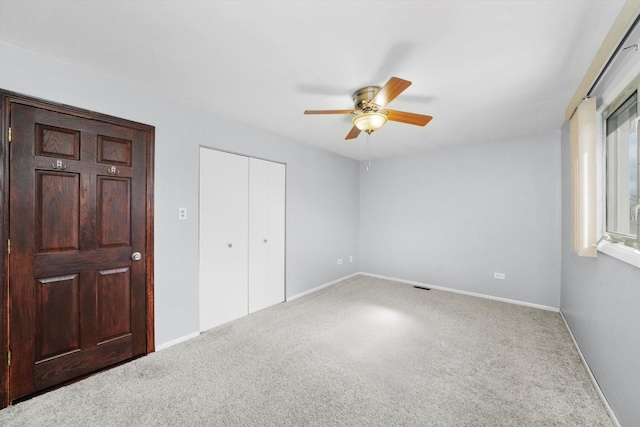unfurnished bedroom featuring carpet floors, baseboards, and a closet