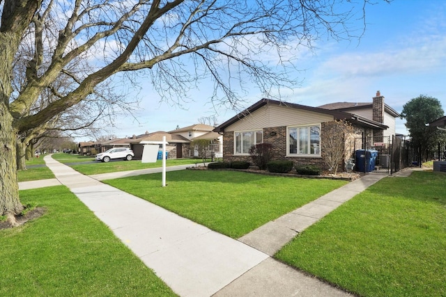 view of front of home featuring a front yard, brick siding, and fence