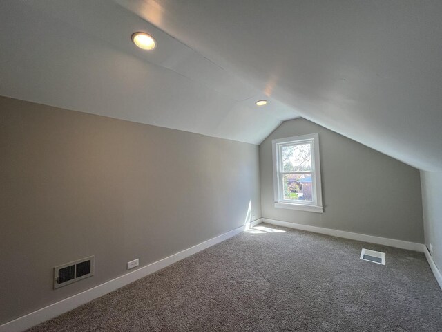 bonus room with carpet flooring, visible vents, baseboards, and vaulted ceiling