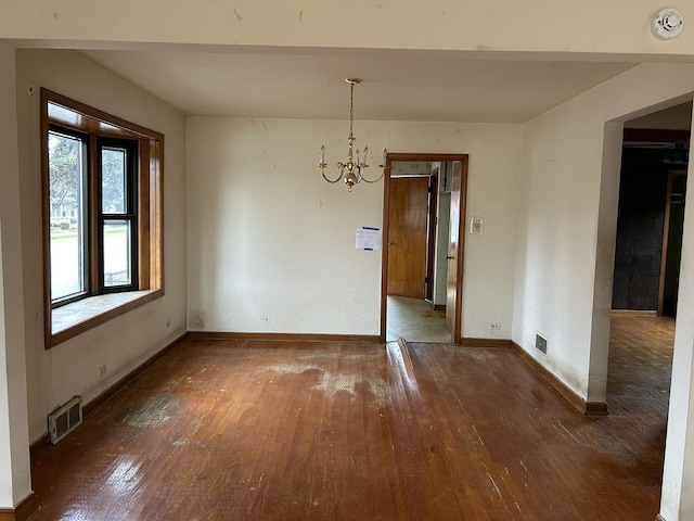 unfurnished dining area with a chandelier, baseboards, visible vents, and hardwood / wood-style flooring