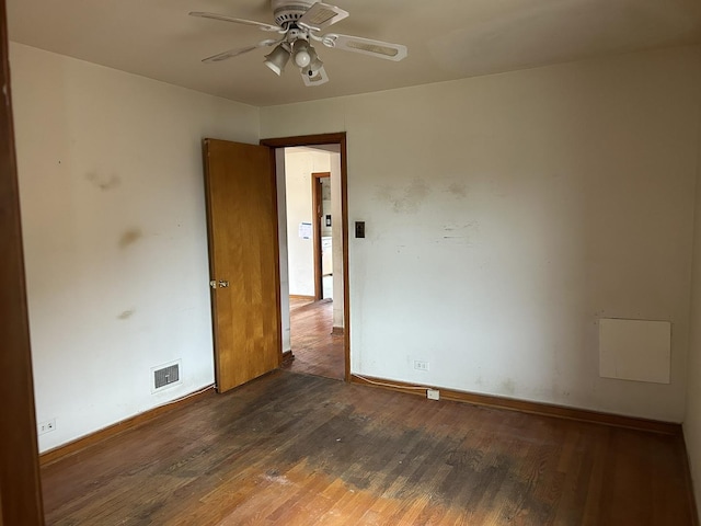 spare room featuring ceiling fan, baseboards, visible vents, and wood finished floors