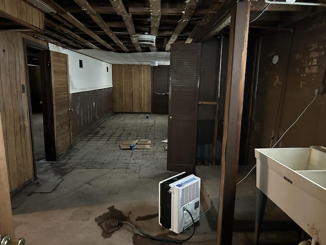 finished basement with wood walls and a sink
