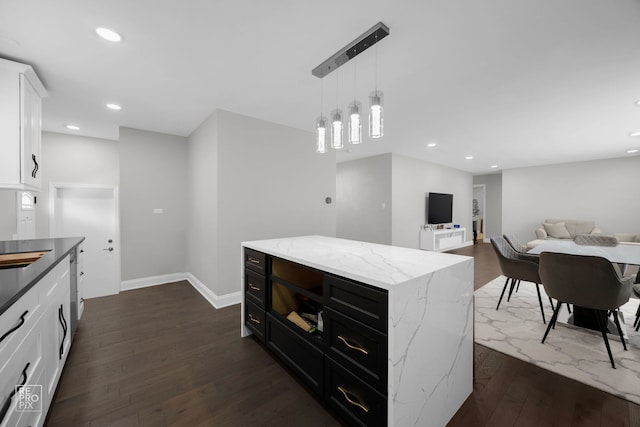 kitchen with light stone countertops, white cabinetry, recessed lighting, dark wood-style flooring, and decorative light fixtures