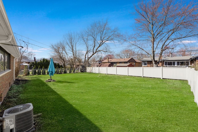 view of yard featuring cooling unit, a fenced backyard, and a residential view
