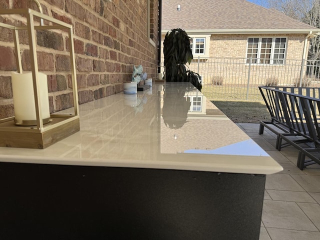 exterior details featuring brick siding and fence