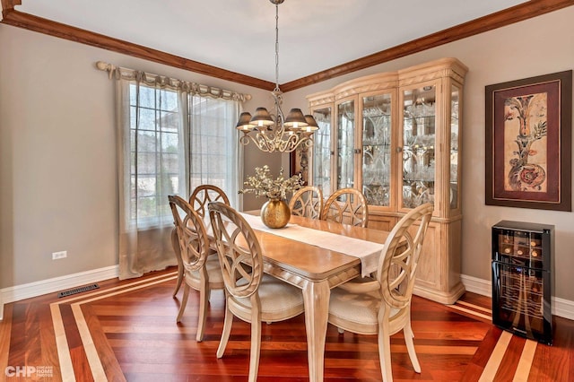 dining room with ornamental molding, visible vents, a notable chandelier, and dark wood finished floors