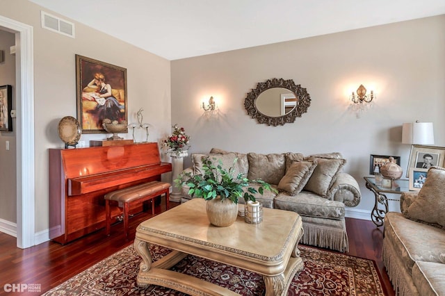 living area featuring visible vents, baseboards, and wood finished floors