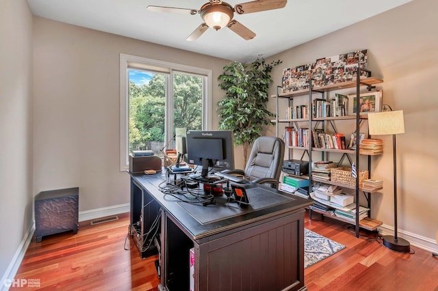 home office with visible vents, baseboards, a ceiling fan, and light wood-style floors