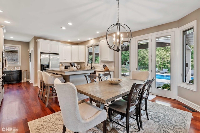 dining room with a chandelier, radiator heating unit, baseboards, and dark wood finished floors