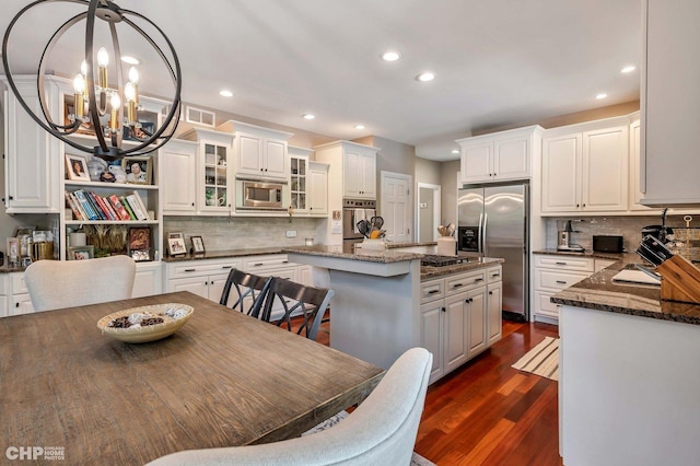 dining space featuring visible vents, recessed lighting, an inviting chandelier, and dark wood-style floors