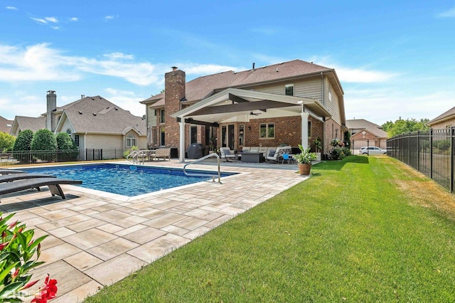 view of swimming pool featuring an outdoor living space, a patio, a fenced backyard, and a lawn