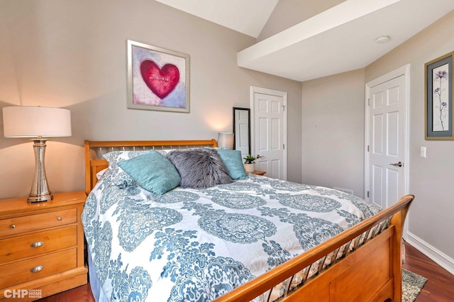 bedroom with baseboards, wood finished floors, and lofted ceiling