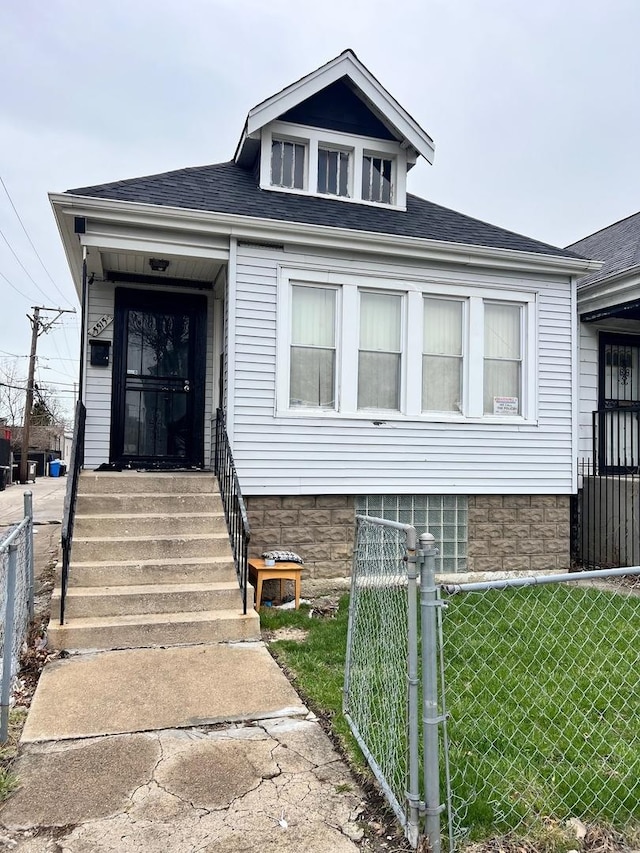 5515 S Hoyne Ave, Chicago, IL 60636 - bungalow-style home featuring a front yard, a gate, a shingled roof, and a fenced front yard