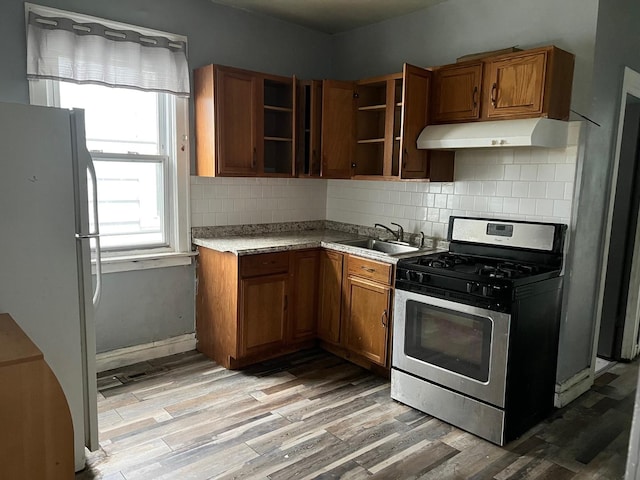 5515 S Hoyne Ave, Chicago, IL 60636 - kitchen featuring freestanding refrigerator, open shelves, gas range, under cabinet range hood, and a sink