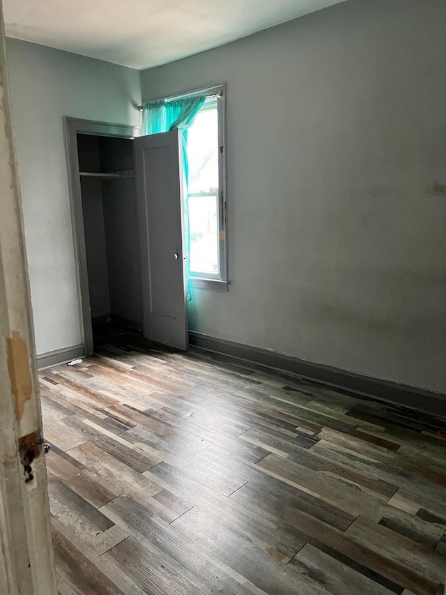 5515 S Hoyne Ave, Chicago, IL 60636 - unfurnished bedroom with a closet, baseboards, and wood finished floors