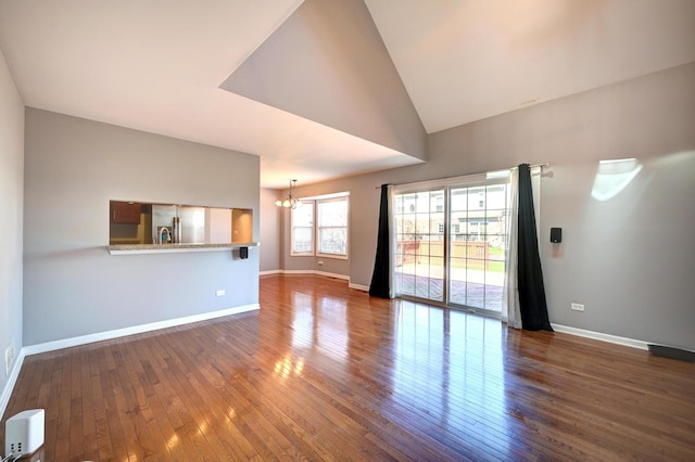 9208 Dexter Ct, Orland Park, IL 60462 - unfurnished living room with a chandelier, wood-type flooring, baseboards, and lofted ceiling