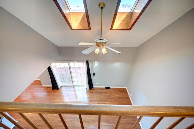 9208 Dexter Ct, Orland Park, IL 60462 - stairway featuring vaulted ceiling with skylight, ceiling fan, wood finished floors, and baseboards