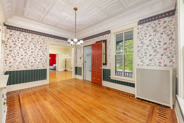 203 High St, West Chicago, IL 60185 - spare room with wallpapered walls, a wainscoted wall, an ornate ceiling, a chandelier, and wood finished floors