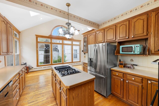 203 High St, West Chicago, IL 60185 - kitchen with stainless steel fridge, gas stovetop, lofted ceiling, a center island, and brown cabinetry