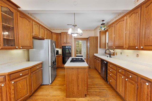 203 High St, West Chicago, IL 60185 - kitchen featuring black appliances, a kitchen island, tasteful backsplash, light wood-type flooring, and brown cabinets